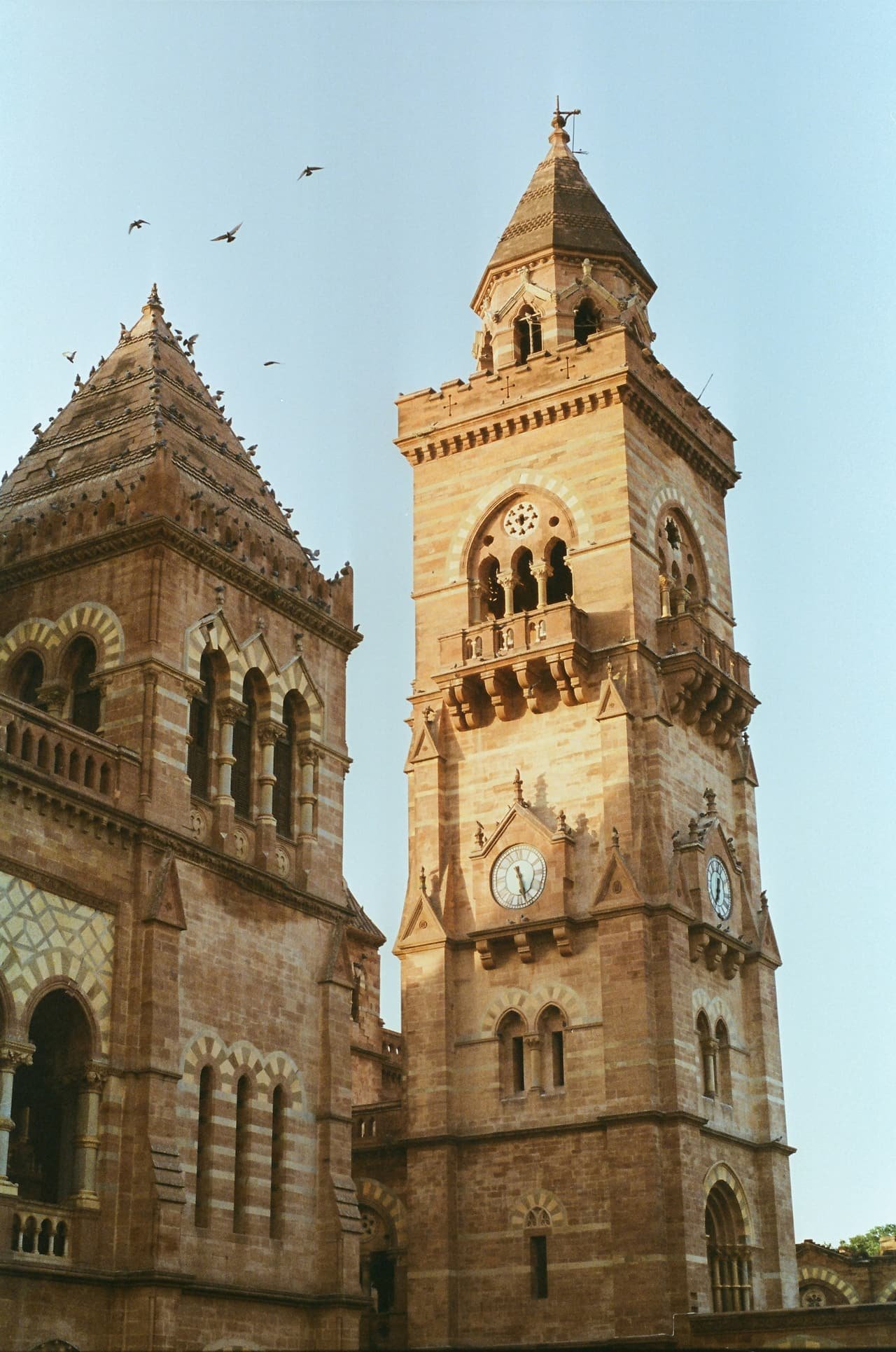 The clock tower of Prag Mahal against a clear sky