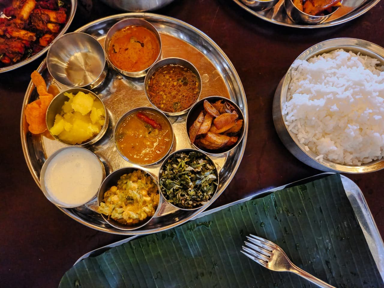 A Gujarati thali with rice, dal and small bowls of curries