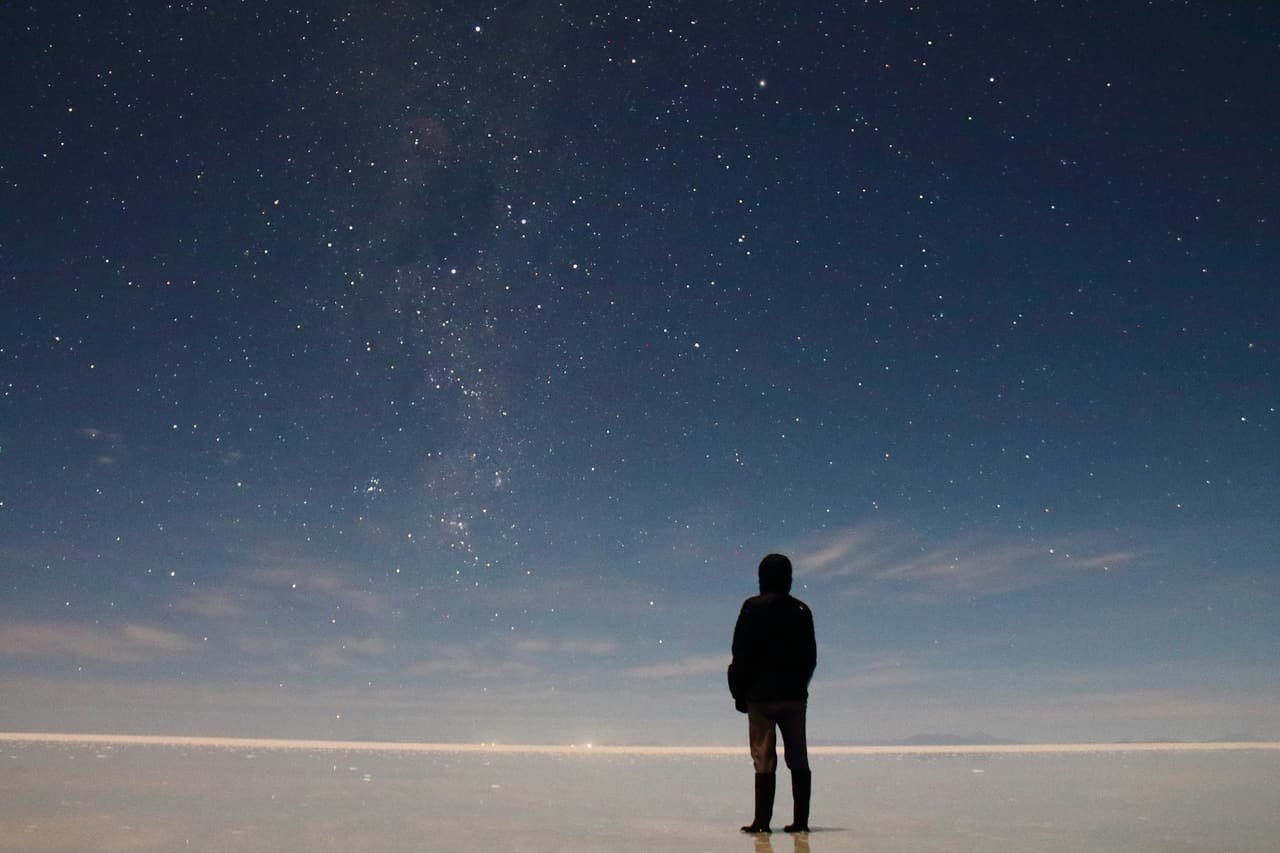 A guest standing on the salt under a sky full of stars