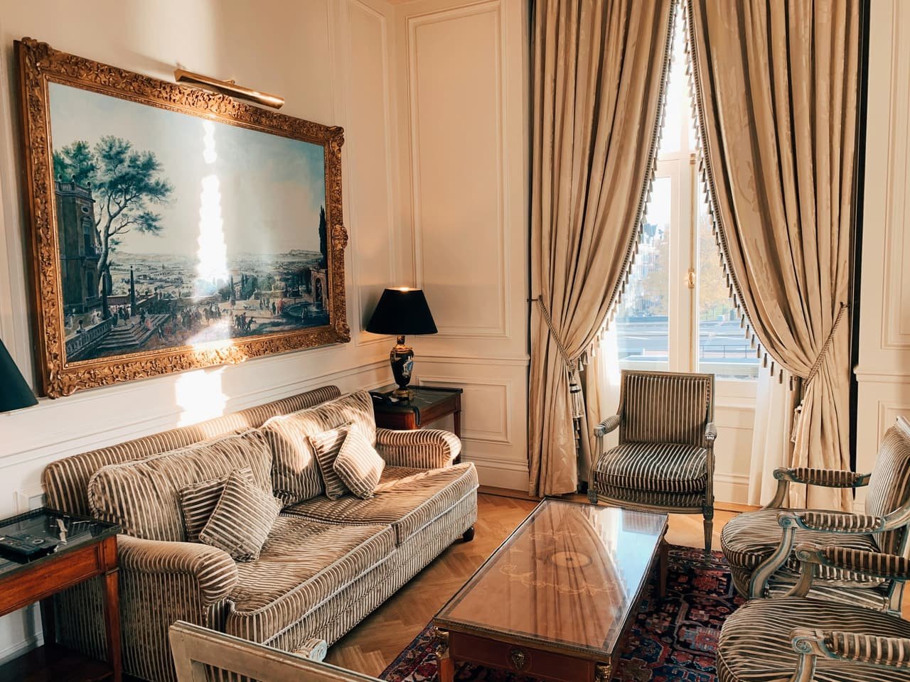 A sitting room with a sofa, armchairs and long curtains
