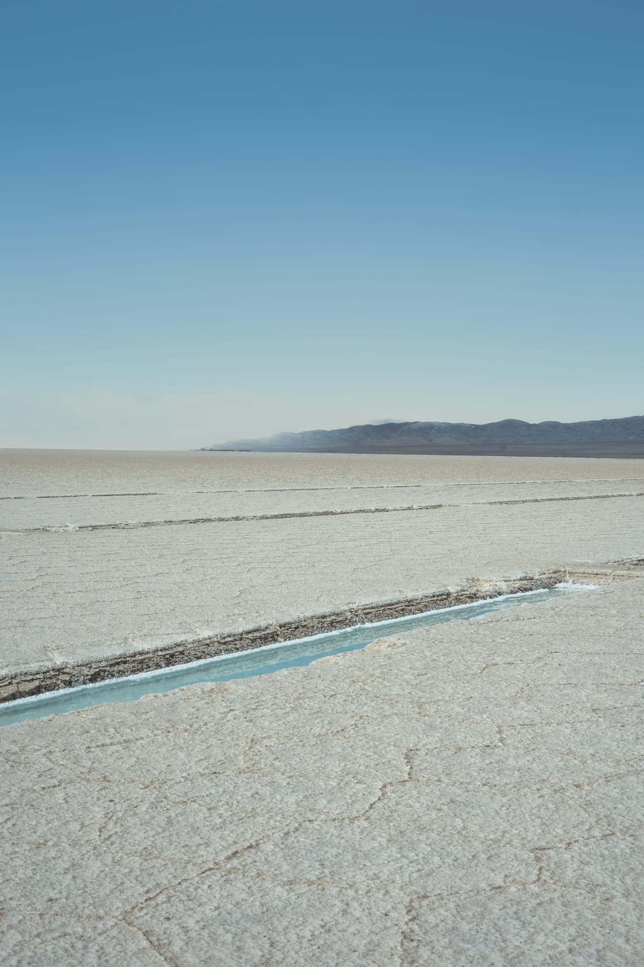 A thin channel of water running through cracked salt