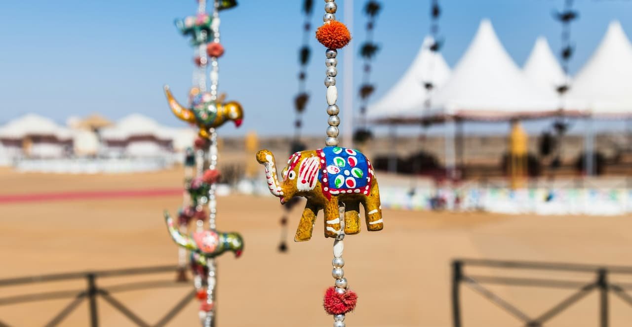Hanging decorations in front of white festival tents