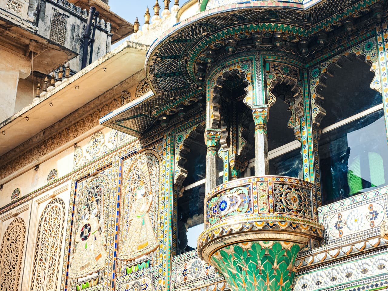 A carved stone balcony with painted arches